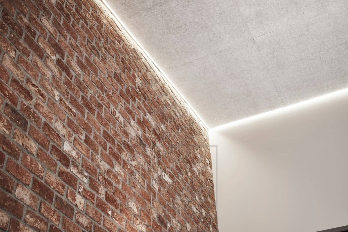 Iluminación indirecta en el techo de un salón alto para resaltar la altura del espacio y crear una iluminación ambiental. Ledstore.fi